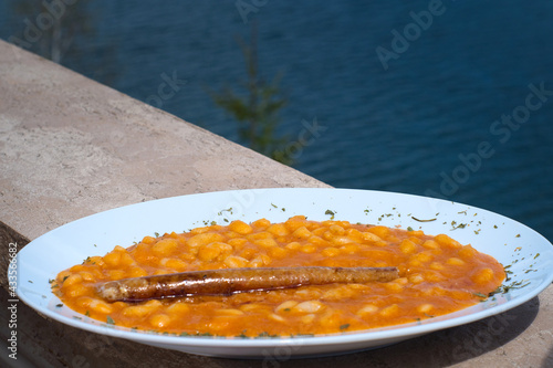 Traditional serbian dish - thick bean soup with the pieces of smoked ham and homemade sausage photo