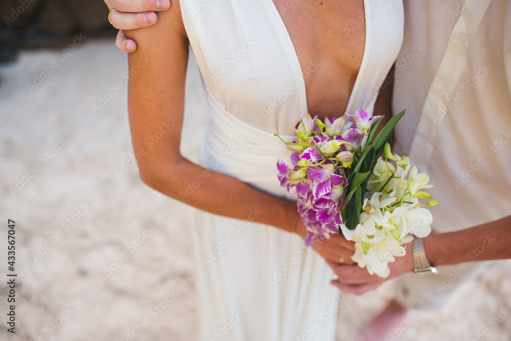 Newlywed groom and bride with wedding bouquet on the beach. The new cell of society Newlywed groom and bride with wedding bouquet on the beach. The new cell of society