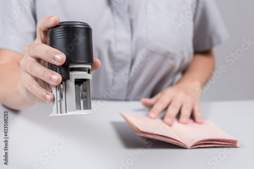 Immigration and passport control at the airport. woman border control officer puts a stamp in the passport. Concept