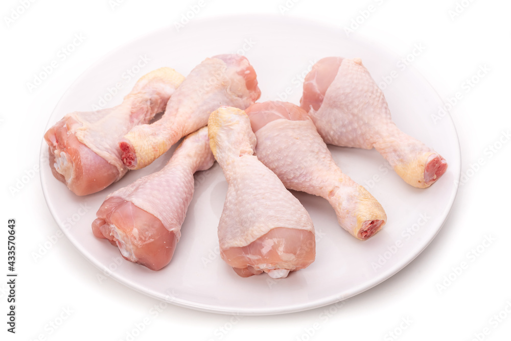 Raw chicken legs on a white plate Raw chicken legs on a white plate