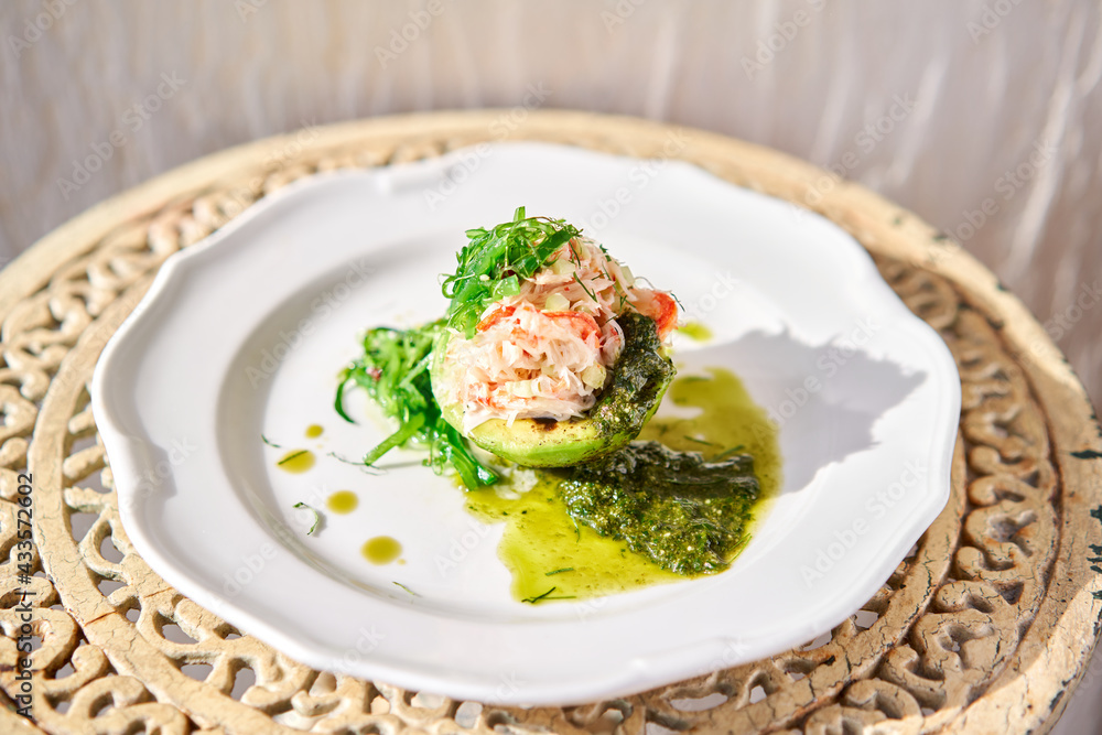 Crab salad tartare. Fresh Crab, avocado and pesto sauce with red caviar on a plate. Selective focus Crab salad tartare. Fresh Crab, avocado and pesto sauce with red caviar on a plate. Selective focus