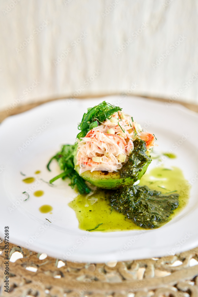 Crab salad tartare. Fresh Crab, avocado and pesto sauce with red caviar on a plate. Selective focus Crab salad tartare. Fresh Crab, avocado and pesto sauce with red caviar on a plate. Selective focus