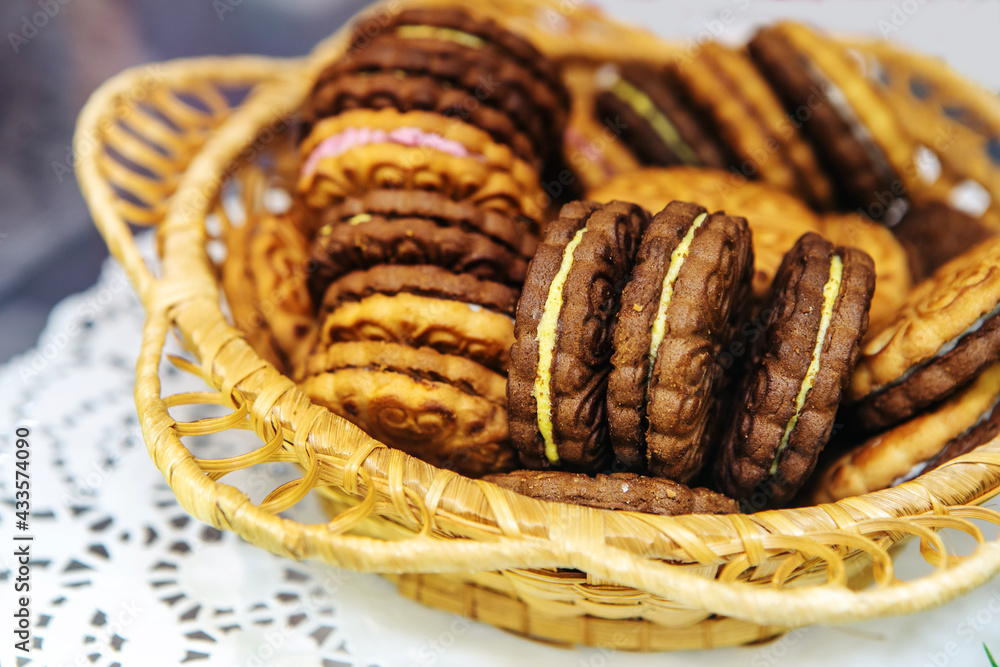 Round cookies with filling. Wheat confectionery in a wicker dish. Close-up