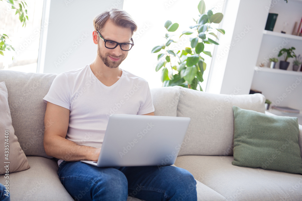 Photo of handsome charming gentleman wear casual outfit sitting sofa working modern device indoors apartment house Photo of handsome charming gentleman wear casual outfit sitting sofa working modern device indoors apartment house