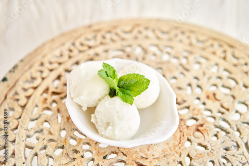Linon ice cream with mint leaf. three balls in a white bowl on a vintage table. sorbet photo