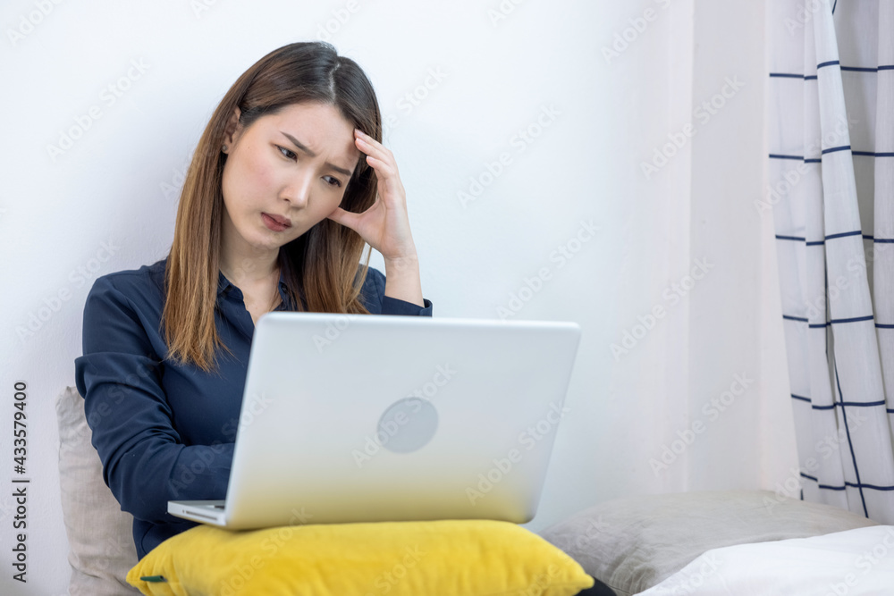 Asian woman uses a laptop computer to work at home, She was stressed and exhausted from work for a long time. Asian woman uses a laptop computer to work at home, She was stressed and exhausted from work for a long time.