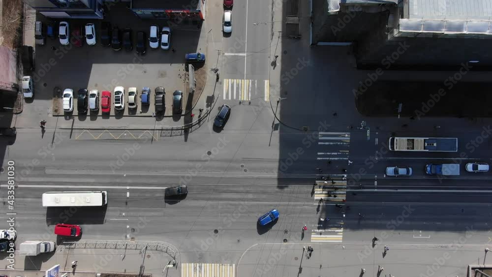 Different automobiles and large lorry drive turning on modern crossroad in city with high buildings on sunny day aerial view Different automobiles and large lorry drive turning on modern crossroad in city with high buildings on sunny day aerial view