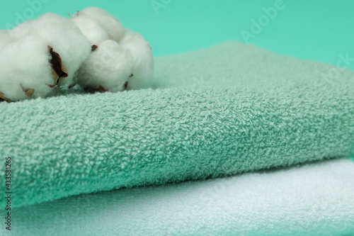 Clean folded towels and cotton on mint background © Atlas