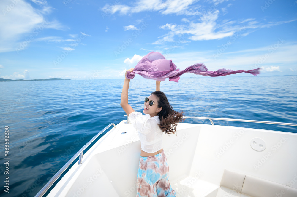 excited tourist enjoying and relaxing on speedboat with a beautiful view of ocean and mountain in backgound