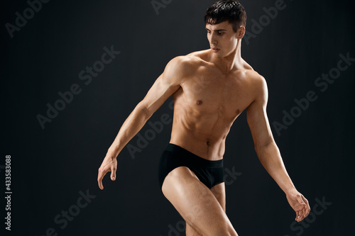 Canvas Print cute male athlete dark coward muscled body studio dark background