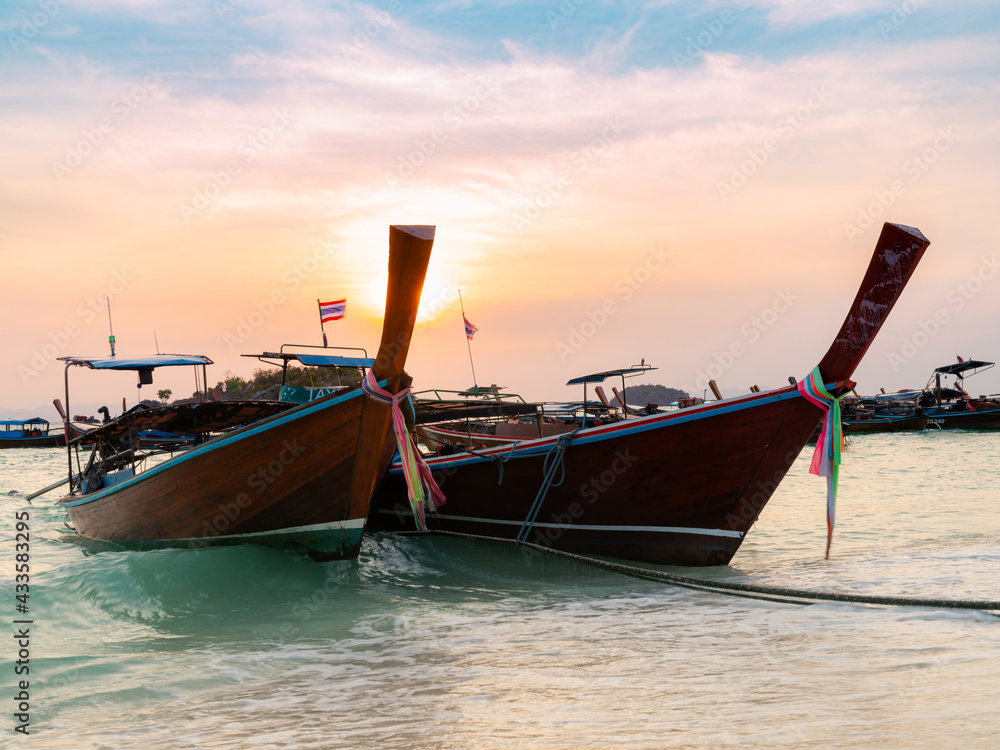 wooden longtail boats parking on green turquoise sea in the morning at Sunrise beach on Lipe Island, Satun, Thailand, peaceful sea view scenic, travel, relax place, traditional transport  