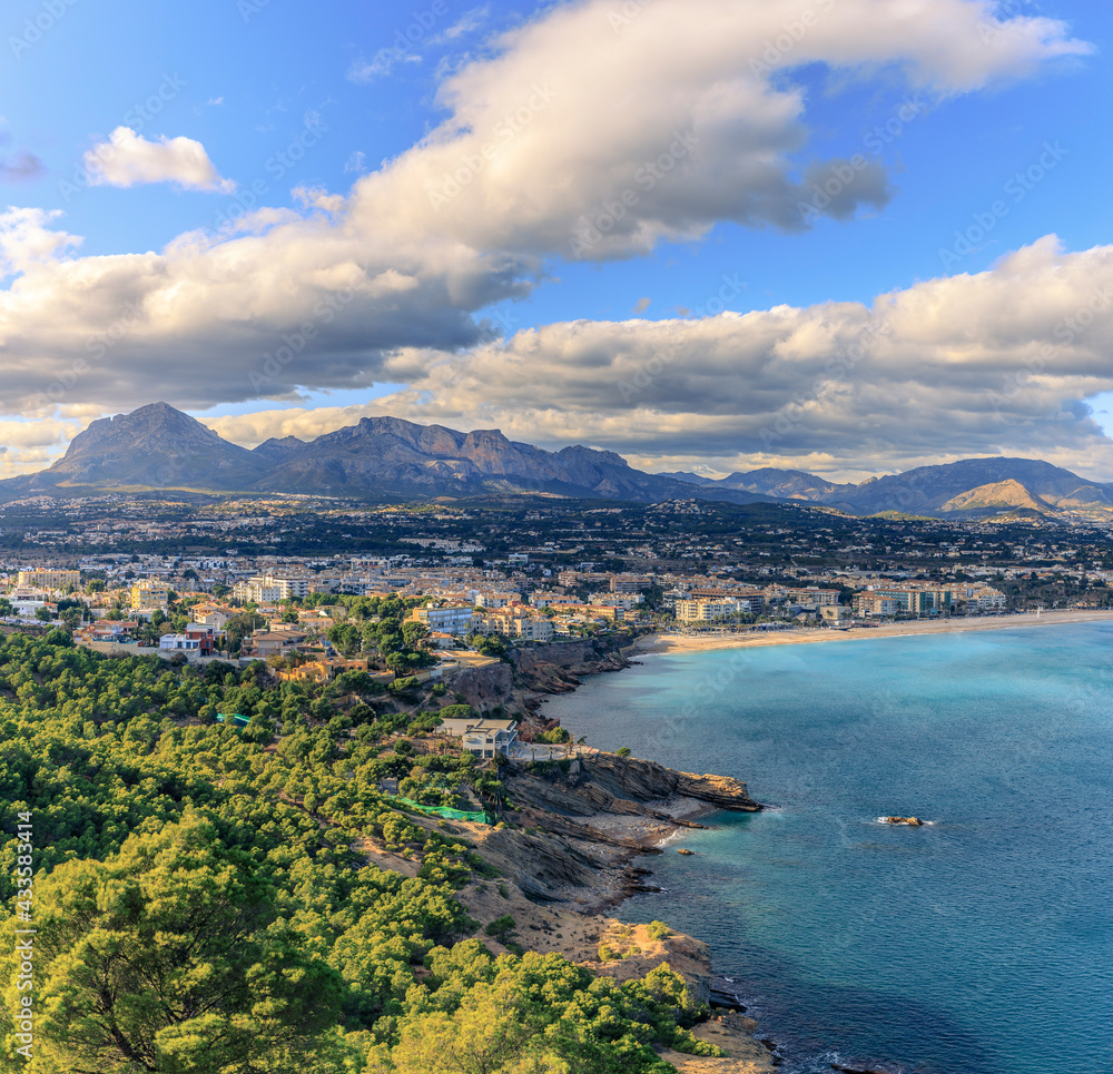 View of the sea, beach, small town and mountains with blue sky and clouds. Square ratio