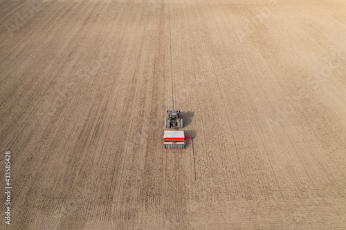 Aerial view of tractor doing farming and sowing wheat in Finland
