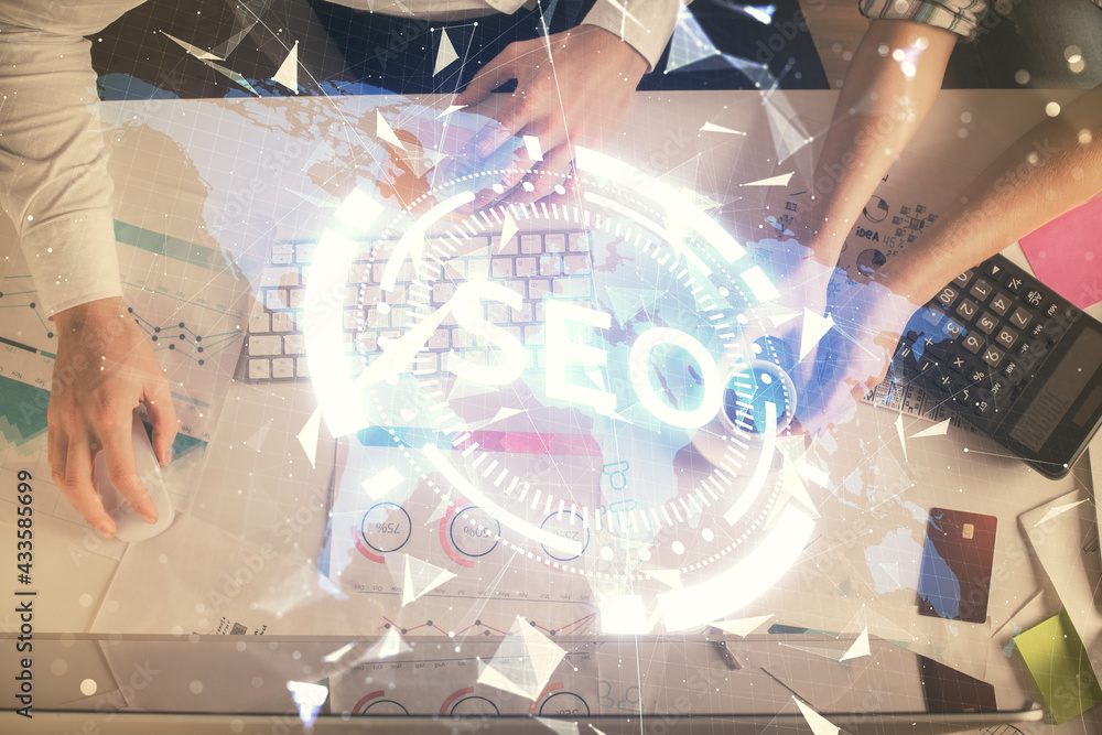 Double exposure of man and woman working together and SEO hologram drawing. Search engine concept. Computer background. Top View. Double exposure of man and woman working together and SEO hologram drawing. Search engine concept. Computer background. Top View.