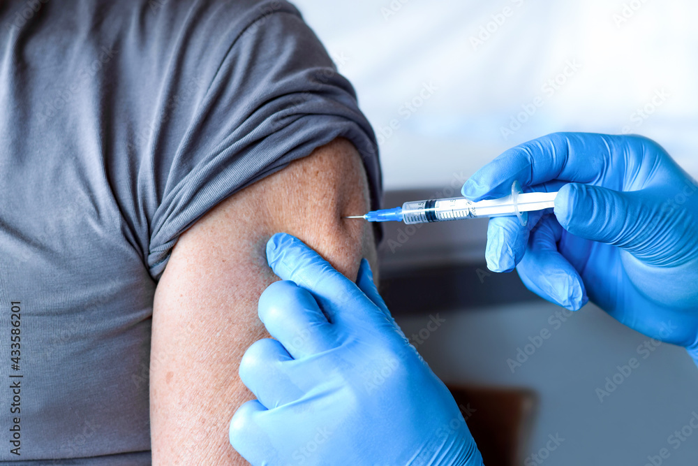 Elderly Man in Face Mask getting Covid Vaccine. Doctor giving Injection to senior Man at Hospital. Virus, COVID-2019, Flu protection. Vaccination of old Patient in Clinic during Coronavirus pandemic. Elderly Man in Face Mask getting Covid Vaccine. Doctor giving Injection to senior Man at Hospital. Virus, COVID-2019, Flu protection. Vaccination of old Patient in Clinic during Coronavirus pandemic.