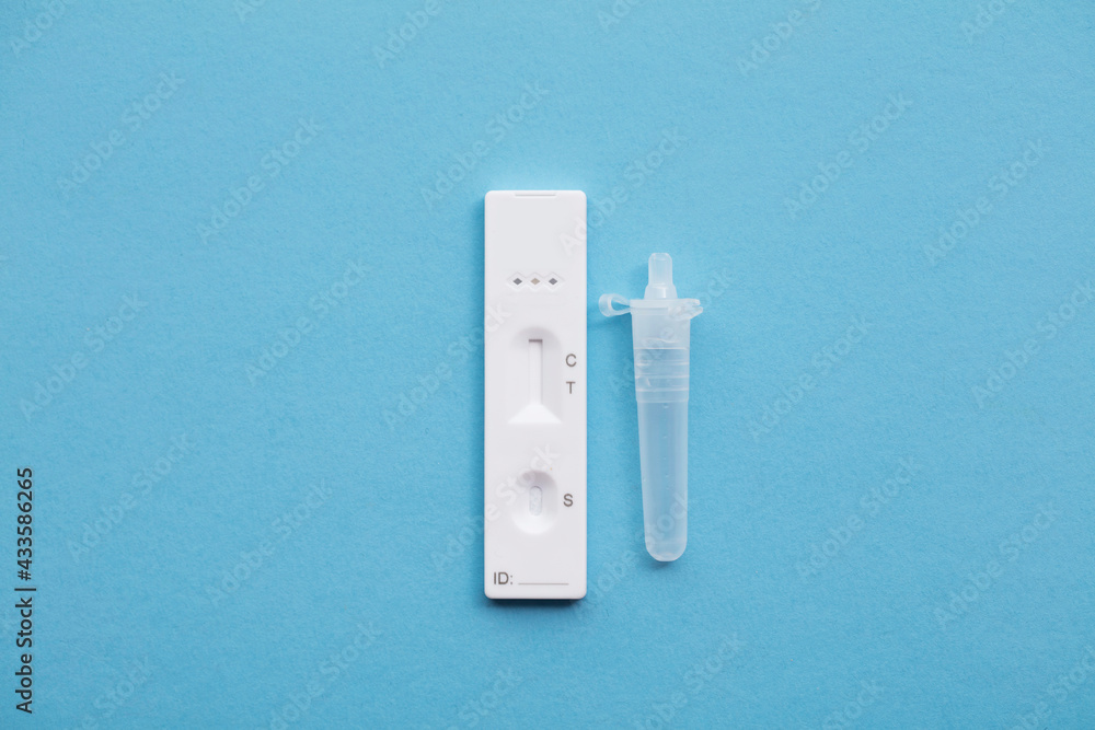 Coronavirus lateral flow home testing kit against a blue background Coronavirus lateral flow home testing kit against a blue background