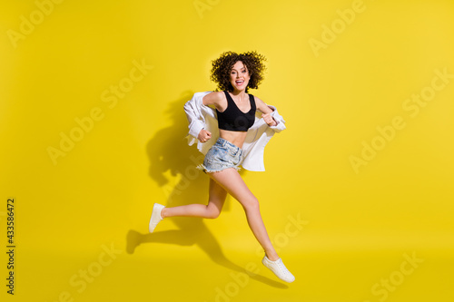 Fototapeta Naklejka Na Ścianę i Meble -  Full size profile photo of optimistic cool girl run wear top shorts shirt sneakers isolated on yellow background