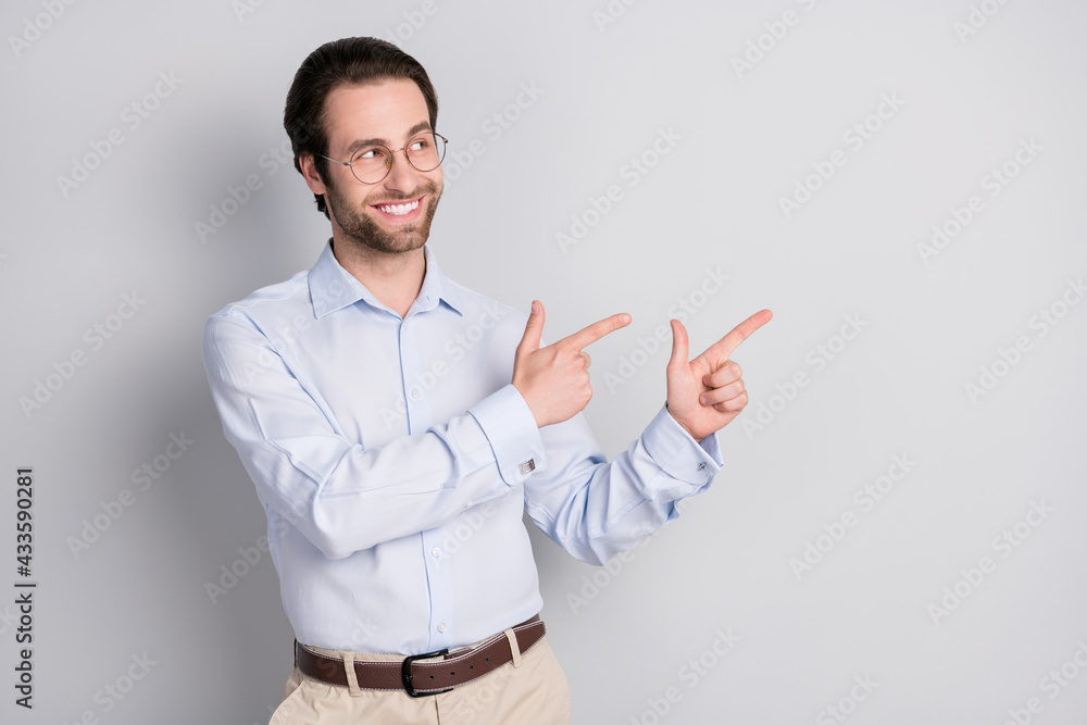 Portrait of attractive cheerful man specialist demonstrating copy space ad advert isolated over grey pastel color background Portrait of attractive cheerful man specialist demonstrating copy space ad advert isolated over grey pastel color background