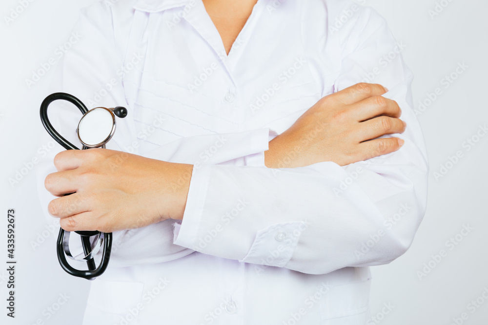 Young doctor with folded arms and stethoscope with white background. Young doctor with folded arms and stethoscope with white background.