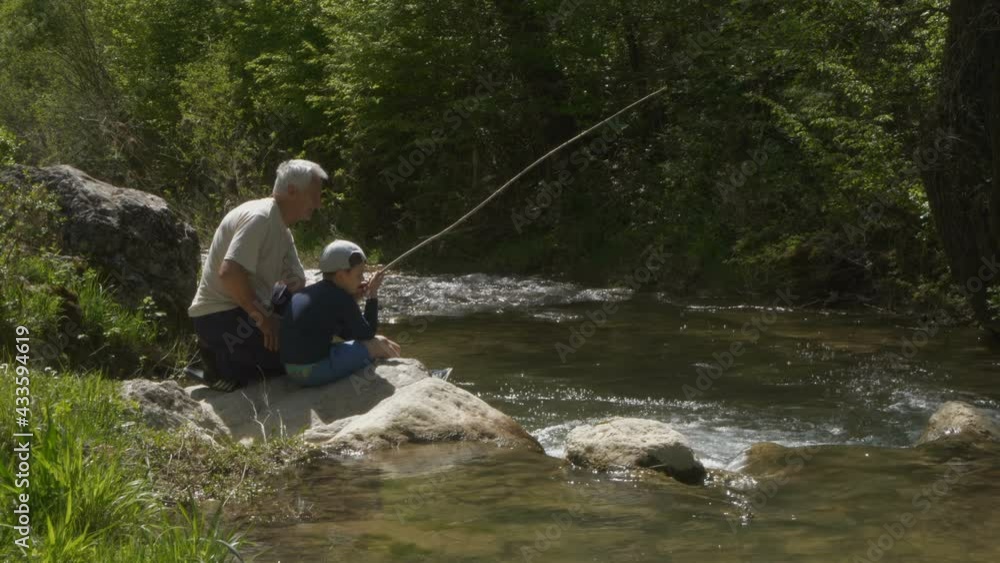 Grandfather and grandson on camping,fishing in the river Grandfather and grandson on camping,fishing in the river