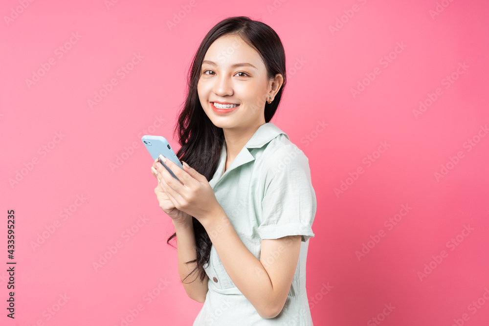 Young Asian woman holding phone to text Young Asian woman holding phone to text