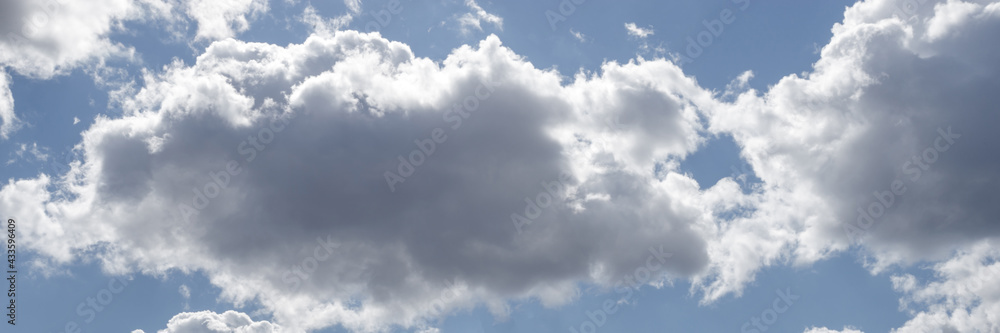 Fototapeta premium blue sky with white clouds backlit by sunlight