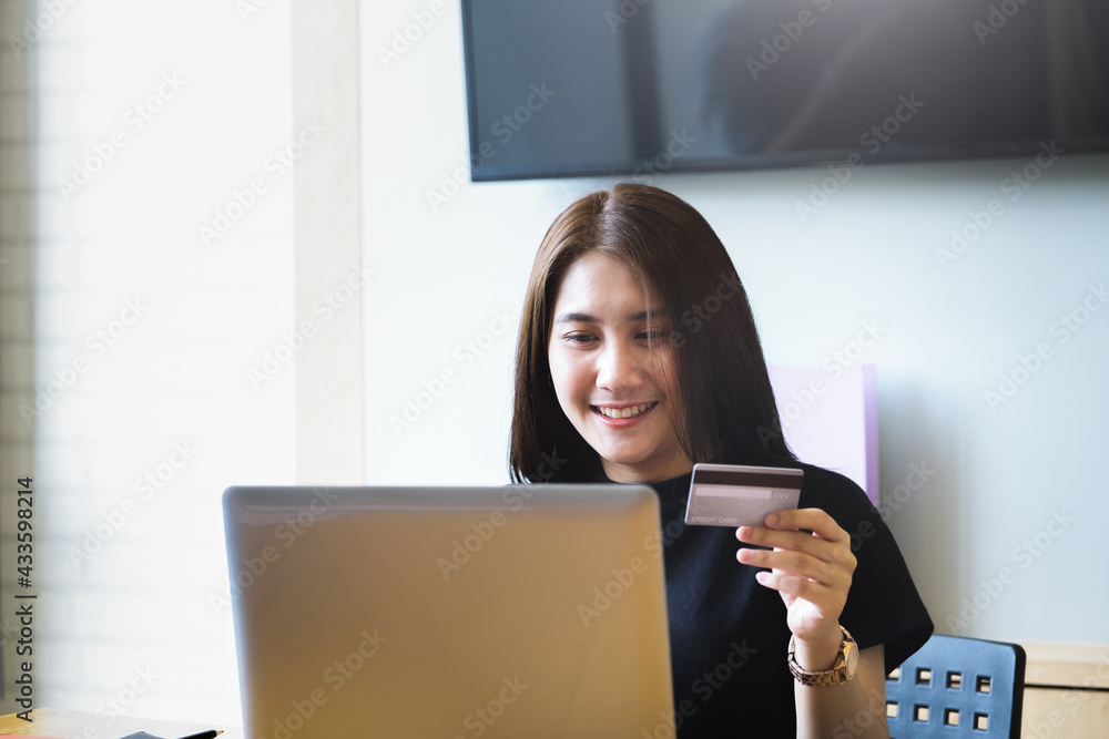 Online payment with Young Women hands holding credit card and using computer for online shopping Online payment with Young Women hands holding credit card and using computer for online shopping