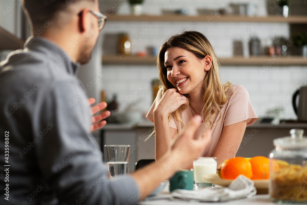 Beautiful young girl enjoying in breakfast with her boyfriend. Loving couple drinking coffee in the kitchen. Beautiful young girl enjoying in breakfast with her boyfriend. Loving couple drinking coffee in the kitchen.