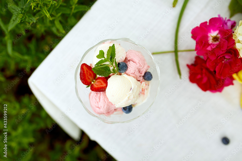 Tasty Ice cream and fresh blueberries, strawberry in the bowl, presented with flower Tasty Ice cream and fresh blueberries, strawberry in the bowl, presented with flower