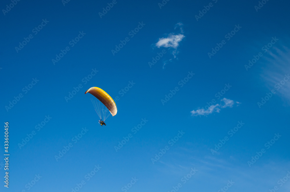 Paragliding against the blue sky. A man flying on a paraglider Paragliding against the blue sky. A man flying on a paraglider