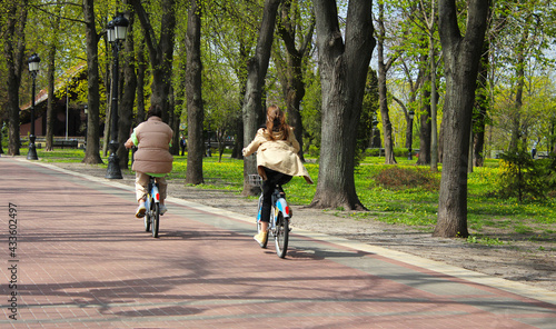 Girls ride a bike in the park. © Nelia