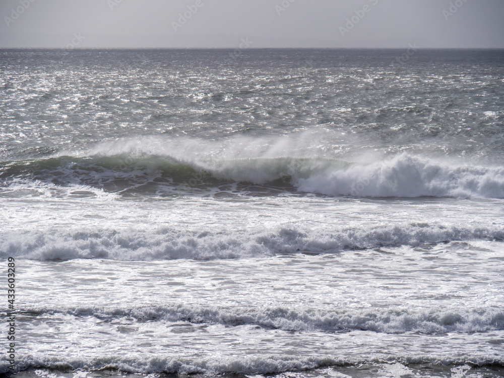 Fototapeta premium Breaking waves and seaspray, no land, Bad weather sea background. UK grey.