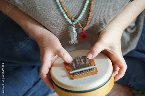 Woman holding and playing a sound healing instrument Sansula for sound healing therapy  photo