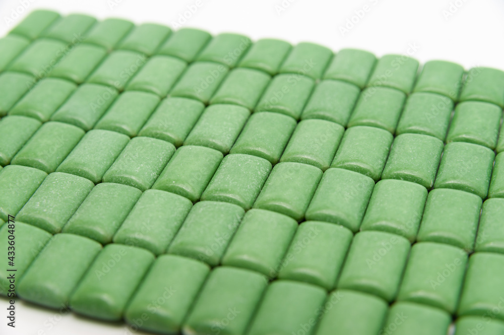 Obraz premium Green mint chewing gum tablets aligned. Isolated on white background. Close-up.