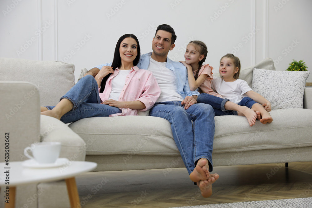 Happy family resting on comfortable sofa in living room Happy family resting on comfortable sofa in living room