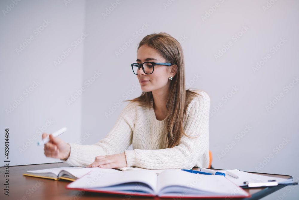 Smiling woman reading notes in planner while working Smiling woman reading notes in planner while working