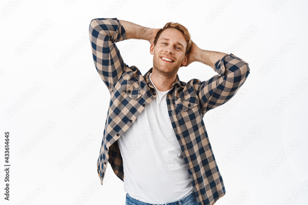 Image of handsome redhead man holding hands behind head and smiling pleased, feeling relaxed and confident, making charming smile, flirty face, standing over white background Image of handsome redhead man holding hands behind head and smiling pleased, feeling relaxed and confident, making charming smile, flirty face, standing over white background