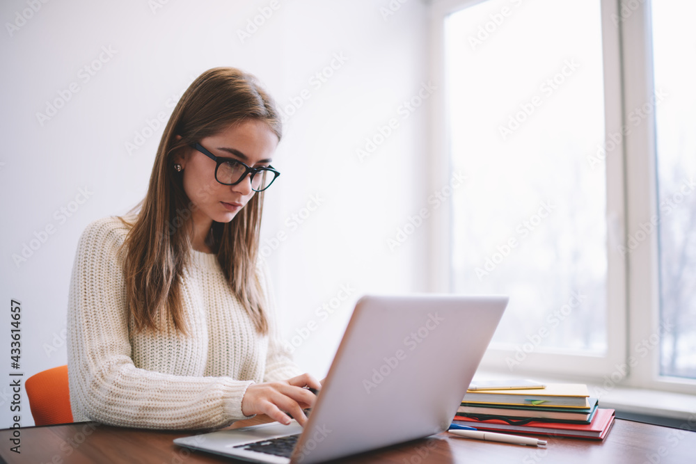 Busy young woman checking information on portable laptop while working remotely Busy young woman checking information on portable laptop while working remotely