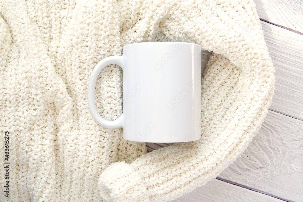 White ceramic coffee mug mockup for design presentation, soft woman sweater  on washed wood background, aesthetic composition. Photos | Adobe Stock