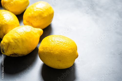 Several ripe lemons on a gray background