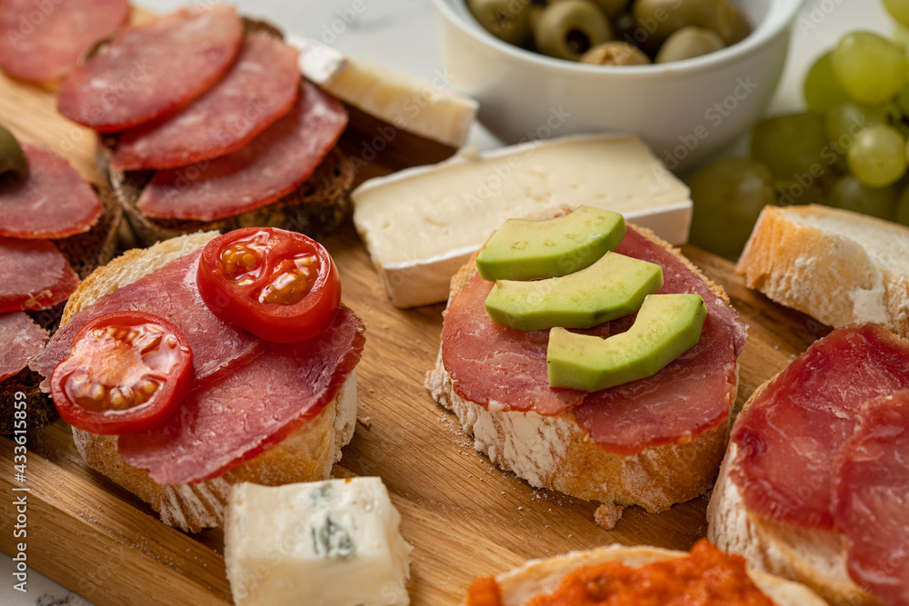 Assortment of sausages and cheese, salami, olives, on white background. Close up