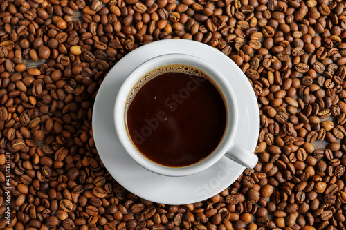 Horizontal banner with a cup of coffee and coffee beans. Top view. Copy space. Espresso or Americano in a cup. Coffee beans background