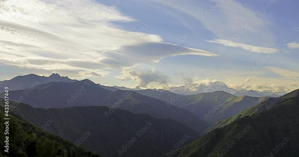 Time lapse of mountain landscape with clouds moving by pleasant wind. Mountain chain covered of green trees in summer.Sunset in the top of a green mountain looking clouds movement, good windy weather. Time lapse of mountain landscape with clouds moving by pleasant wind. Mountain chain covered of green trees in summer.Sunset in the top of a green mountain looking clouds movement, good windy weather.