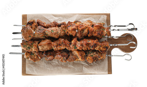 Metal skewers with delicious meat on white background, top view photo