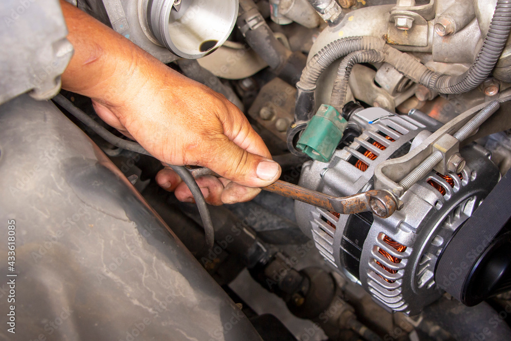 machanic or worker hand-holding wrench repair car alternator in a garage. Repairing and maintenance automobile concept machanic or worker hand-holding wrench repair car alternator in a garage. Repairing and maintenance automobile concept