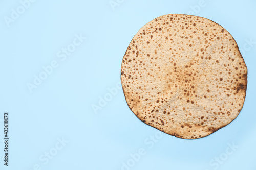 Tasty matzo on light blue background, top view with space for text. Passover (Pesach) celebration