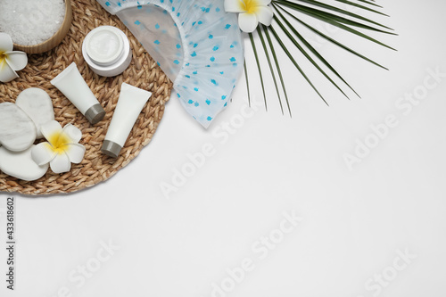 Flat lay composition with shower cap and toiletries on white background. Space for text