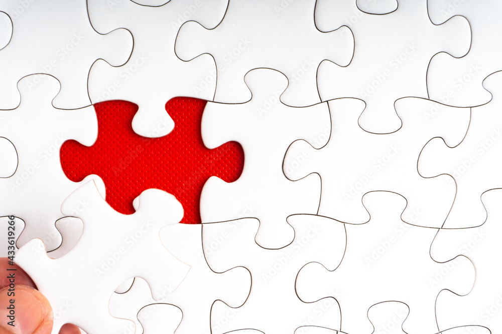 Hands holding Red jigsaw puzzle pieces on red background. Copy space and business concept Hands holding Red jigsaw puzzle pieces on red background. Copy space and business concept