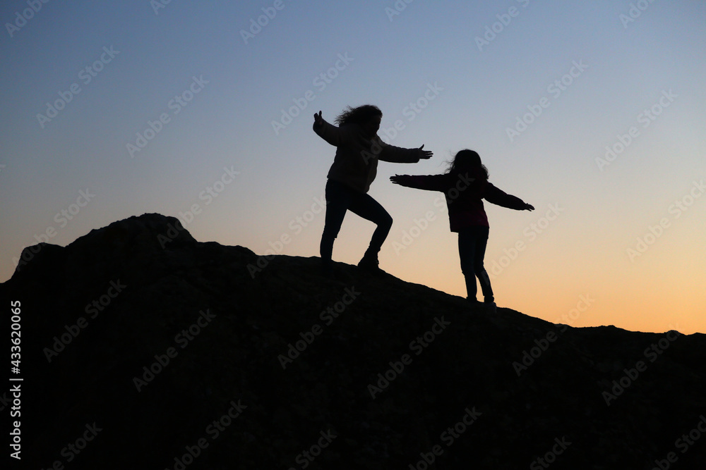 silhouettes of people in the mountain with sunrise sky background silhouettes of people in the mountain with sunrise sky background