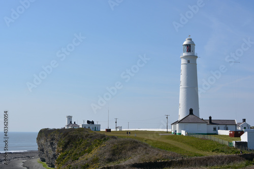 Nash Point Lighthouse in the Vale of Glamorgan, Wales with a blue sky on a sunny spring day photo